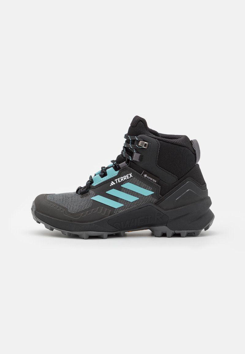 Botte de randonnée noire et grise avec des rayures turquoise, maintien renforcé de la cheville, semelle robuste et fermeture par lacets, conçue pour une utilisation en extérieur.