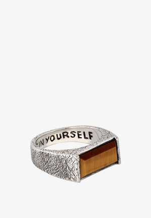 Bague argentée texturée avec une pierre œil de tigre rectangulaire et l'inscription "IN YOURSELF" à l'intérieur de l'anneau.
