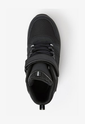 Schwarzer High-Top-Schuh mit strukturiertem Obermaterial, ausgestattet mit einem Riemen, Schnürsenkeln und reflektierenden Akzenten. Glattes Innenfutter und gepolsterter Schaft für zusätzlichen Komfort.