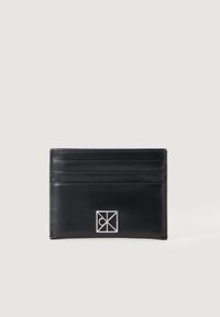 Melna ādas kredītkaršu maka forma ar vairākiem slotiem, augsta precizitāte ar izceltu sudraba logotipu un gludu tekstūru. Minimalistiska taisnstūra forma.