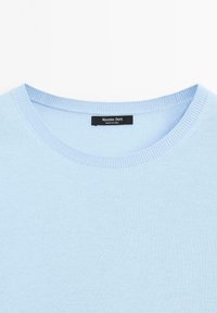 Lichtblauwe gebreide trui met ronde halslijn, zachte textuur en geribbelde accenten bij de kraag, met label "Massimo Dutti."