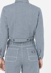 Randig denimjacka med en kortad design, knappstängning och ärmslut, som kombineras med matchande randiga byxor med fickor.