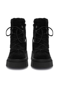 Cizme scurte din suede negru cu un partea superioară pufoasă, având șireturi negre, gauri metalice pentru șireturi și o talpă chunky. Detalii texturate pe suprafață.
