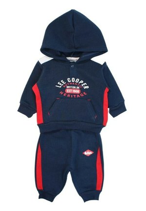 Survêtement bleu marine avec des accents rouges. Comprend un sweat à capuche avec une poche avant et un pantalon assorti avec un petit logo sur la jambe.