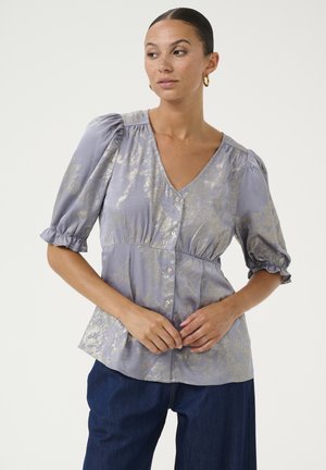 Lavender Bluse mit seidiger Textur, kurzen Puffärmeln, V-Ausschnitt, goldfarbenem Blumenmuster, Knopfleiste und gerafftem Taillenbereich.