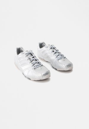 Zilveren sport schoenen met een gladde, glanzende textuur; gebogen ontwerp; grijze veters; rubberen zolen met grip patronen; ronde neus.