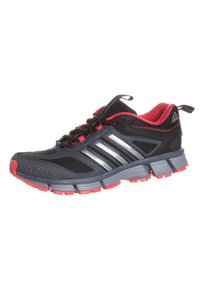 Černá sportovní bota s červenými detaily, se síťovinovými panely, třemi kovovými pruhy a texturovanou gumovou podrážkou pro lepší přilnavost.