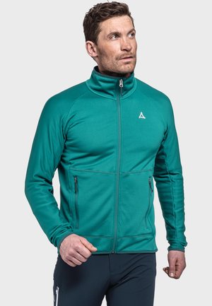 Türkise Sport-Zipjacke mit hohem Kragen, strukturiertem Stoff und zwei seitlichen Reißverschlusstaschen. Mit einem Logo auf der linken Brust.