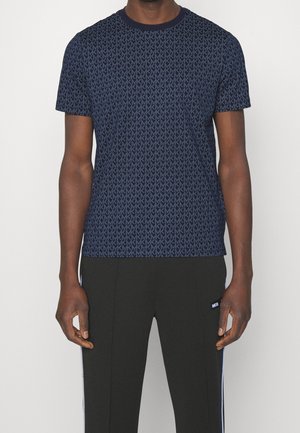 Navy blue short-sleeve t-shirt with repeating logo pattern, crew neckline, and soft fabric; paired with black athletic pants featuring side branding.