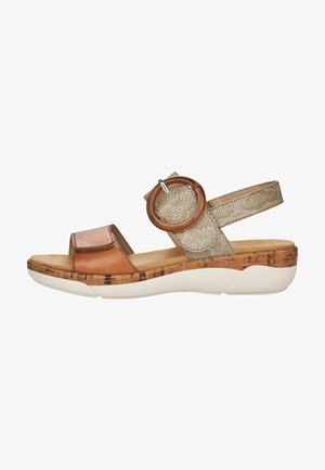Sandale en cuir marron avec une semelle en liège, une sangle texturée dorée et un détail d'accent circulaire. Design ouvert à l'avant avec sangle de cheville réglable.