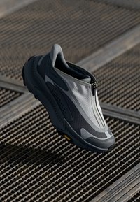 Tenisi gri și negri cu închidere cu fermoar, panouri texturate și talpă Vibram. Design elegant cu un profil subțire și ușor.