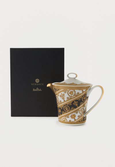 Λευκό πορσελάνινο τσαγιέρα με χρυσά και μαύρα διακοσμητικά μπαρόκ μοτίβα, χρυσό περίγραμμα και κυρτή λαβή, δίπλα σε μαύρο κουτί Versace Rosenthal.