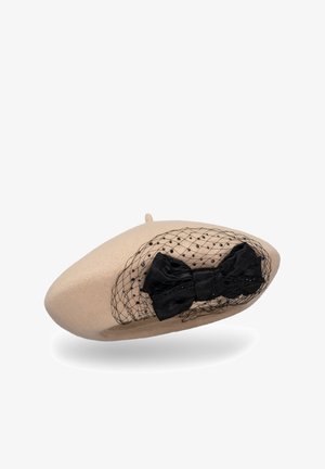 Béret en laine beige avec un nœud en satin noir et un filet à petits pois, créant un design texturé avec des accents élégants.