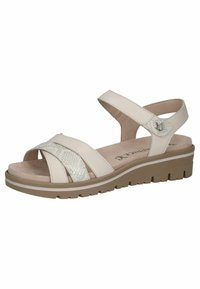 Sandales beiges avec des brides croisées, présentant une bande texturée avec des accents pailletés. Conçues avec un petit compensé et une semelle en caoutchouc.