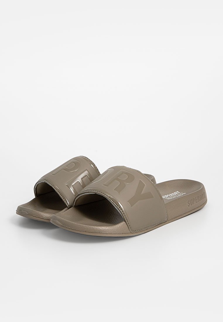 Sandales en plastique vert olive avec de larges brides présentant le texte en relief "SUPERDRY". Semelle lisse de forme arrondie pour un confort optimal.