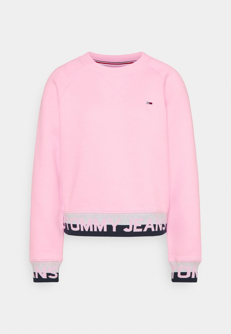 Sweat-shirt rose clair à manches longues, avec poignets et ourlet marine et gris, avec le texte "Tommy Jeans" et un petit logo sur la poitrine.