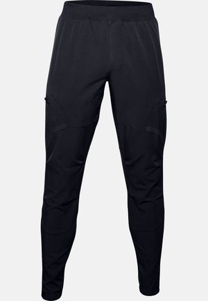 Pantalon de sport noir avec taille élastique et poches latérales zippées, conçu avec des détails en panneaux et des jambes fuselées.