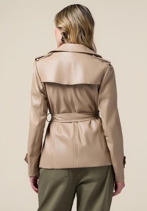 Giacca in ecopelle beige con vita cintura, design aderente e ampie bocchette. Presenta spalline e una superficie liscia.