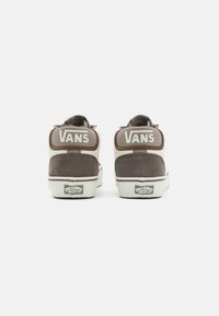 Zapatillas altas de ante gris con suelas de goma blanca. Gran logo de "VANS" en los cuellos acolchados de los tobillos. Diseño sencillo con acentos en contraste.