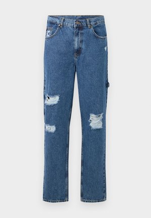 Blue denim jeans with distressed patches on both legs, five-pocket design, button closure, and belt loops.