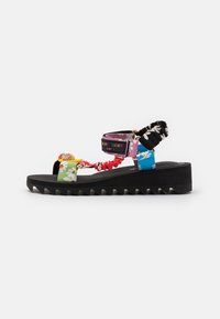 Černé platformové sandály s vroubkovanou podrážkou, vícebarevné květinové pásky, zkrčené elastické pásky a štítek "Kurt Geiger London" na pásku kolem kotníku.
