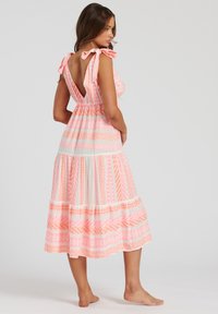 Rosafärgad och vit mönstrad klänning med V-ringning i ryggen, knytband och strepetskjol. Har geometriska mönster i olika nyanser av rosa.