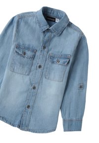 Camicia button-up in denim azzurro chiaro con colletto, due tasche sul petto e maniche lunghe, caratterizzata da bottoni scuri e una texture leggermente sbiadita.