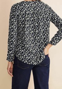 Langärmliges Oberteil mit einem navy-weißen abstrakten Muster, aus weichem Stoff, mit gerafftem Rückenteil, runder Halslinie und lässiger Passform.