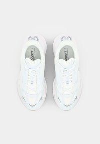 Hvite sneakers med en teksturert mesh-overdel med lyseblå detaljer. Kraftig såle, runde lisser og en liten logo på tungen.