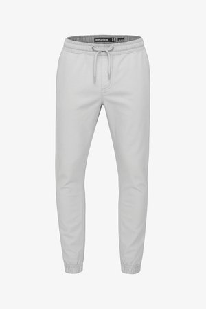 Pantalones jogger gris claro con cintura elástica, cordón ajustable, bolsillos laterales y puños elásticos en los tobillos.