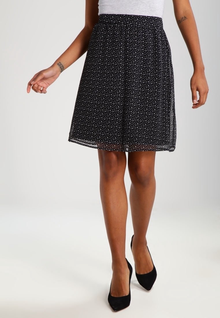 Schwarze, knielange Skirt aus durchsichtiger, leichtgewichtiger Textur mit einem weißen Punktmuster und einem elastischen Bund.