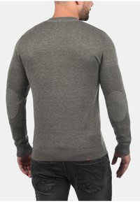 Grijze gebreide trui met een ronde hals, geribde mouwen en elleboogpatches, met een gladde textuur en slank aansluitende pasvorm.