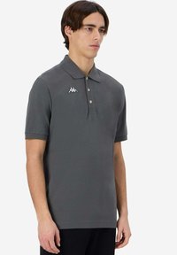 Polo grigio in cotone, con colletto classico, tre bottoni e un piccolo logo bianco sul lato sinistro del petto. Maniche corte.