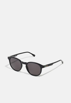 Óculos de sol pretos com armações arredondadas, lentes cinza-escuro e hastes pretas elegantes com um pequeno detalhe em verde e dourado.