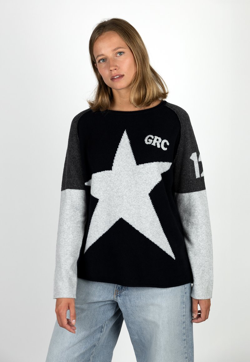 Black and grey sweater with a large white star design, featuring the text "GRC" and "12." Made from a soft, knitted material.