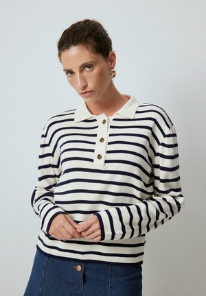 Gestreepte lange mouwen polo in roomkleur en marineblauw, met een knoopsluiting en geribbelde mouwen, gemaakt van zacht materiaal met een relaxte pasvorm.