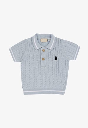 Polo en tricot bleu clair à manches courtes, arborant un motif en cables texturé, deux boutons en bois et un logo de teddy bear noir.