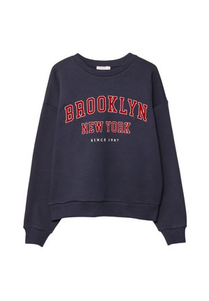 Námornícky modrá mikina s okrúhlym výstrihom, na ktorej sú v tučnom červenom písme napísané "BROOKLYN NEW YORK" a pod tým menším písmom "SINCE 1987". Mäkkučký na dotyk.