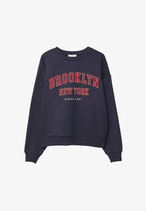 Granatowa bluza z okrągłym dekoltem, z dużym czerwonym napisem "BROOKLYN NEW YORK" oraz mniejszym tekstem "SINCE 1987" poniżej. Miękka w dotyku.
