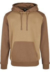 Brun hette med en lysere beige front og mørkere brune raglanermer. Har en frontlomme i kenguru-stil og justerbar snor i hetten.