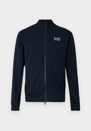 Temno modra jopica z zadrgo in visokim ovratnikom, izdelana iz gladkega materiala. Na prsih ima majhen logotip EA7 in oprijete manšete.