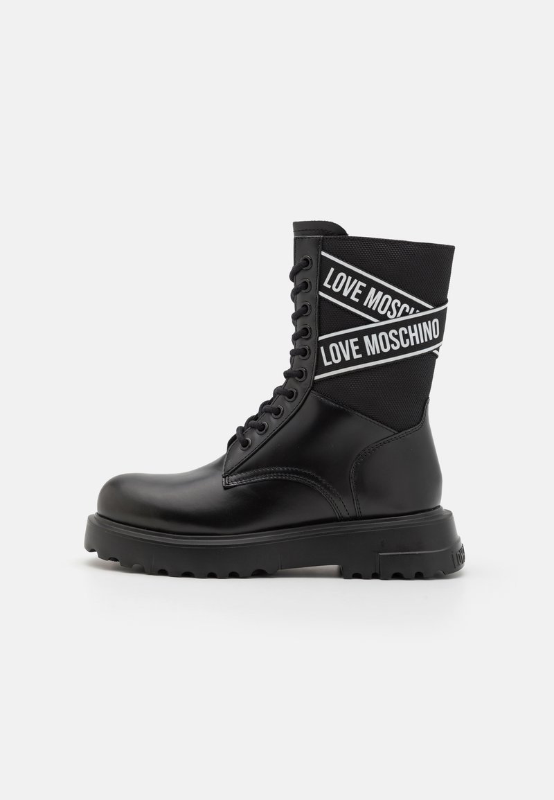 Mustade pahklööbid, millel on sile nahast välimus, nööbid ja tekstuuriga kangas ülemine osa valge "LOVE MOSCHINO" brändimisega.