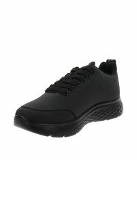 Zapatillas deportivas negras con parte superior texturizada, punta redonda, diseño de cordones y una suela acolchada con un patrón de puntos.
