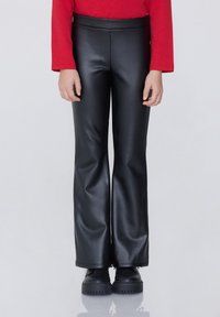 Černé kalhoty s vysokým pasem ze syntetické kůže, s hladkým povrchem, které mají těsný střih v bocích a široké nohavice.