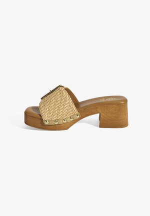 Beige woven platform sandal with a chunky wooden heel, featuring gold studs along the edge and a square upper design.