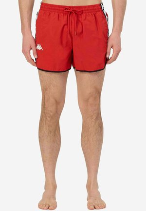 Pantaloni da bagno rossi con vita regolabile, rifiniture nere e dettagli laterali che presentano un logo bianco. Realizzati in un tessuto leggero e liscio.