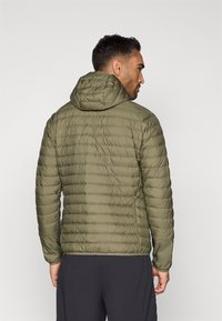 Casaco acolchoado em verde oliva, com capuz, design matelassado e tecido leve. Mangas ajustáveis e textura suave.