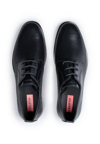 Scarpe da uomo in pelle nera con un design perforato, punta rotonda e chiusura con lacci. Presentano una soletta morbida con un logo rosso del marchio sulla linguetta.