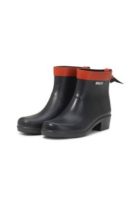 Botas de tobillo de goma negras con un acento rojo alrededor del cuello, suela plana y un pequeño tacón. Presenta un logo de la marca en el lateral.