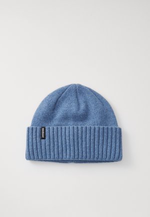 Gorro de malha azul com punho dobrado e etiqueta de marca pequena sobre um fundo branco.